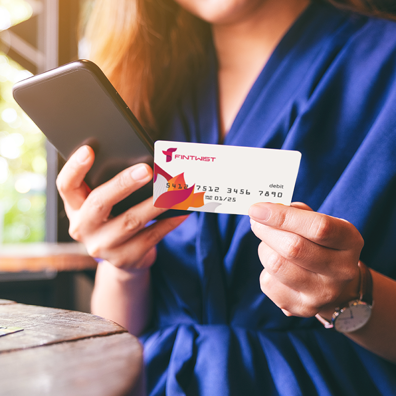 woman in blue dress with phone and Fintwist corporate disbursement card